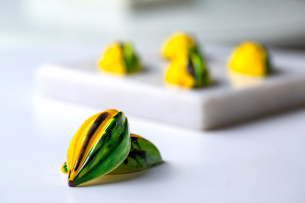 Green and yellow triangular snacks on a white surface with a blurred background